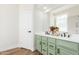 Bathroom with double sinks, green cabinets, and a large mirror at 3649 E Cody Ave, Gilbert, AZ 85234