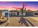 Single-story house with gray garage door, landscaping, and a saguaro cactus at 4055 E Hearn Rd, Phoenix, AZ 85032