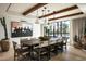 Elegant dining room with rustic wood table, designer lighting, and poolside views at 4849 N Camelback Ridge Dr # A101, Scottsdale, AZ 85251