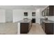 Island kitchen with granite counters, sink, and black cabinets at 5087 E Umber Rd, San Tan Valley, AZ 85143