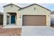 Charming single-story home featuring a two-car garage, stylish blue front door, and low-maintenance desert landscaping at 5152 E Umber Rd, San Tan Valley, AZ 85143