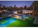 Night view of house, pool, and sports court at 5817 E Leith Ln, Scottsdale, AZ 85254