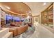 Expansive living area with a stone fireplace, large windows, and a wet bar at 6520 E El Sendero Rd, Carefree, AZ 85377