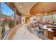 Open floor plan living area with stone flooring and curved walls of windows at 6520 E El Sendero Rd, Carefree, AZ 85377
