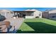 Spacious backyard with covered patio, artificial turf, and built-in grill at 12657 W Myrtle Ave, Glendale, AZ 85307
