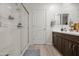 Modern bathroom with walk-in shower, double vanity, and dark brown cabinets at 12657 W Myrtle Ave, Glendale, AZ 85307