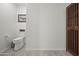 Clean and modern bathroom with a toilet and a wooden storage cabinet at 12657 W Myrtle Ave, Glendale, AZ 85307