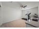 Bright bedroom with a treadmill, desk, and window coverings at 12657 W Myrtle Ave, Glendale, AZ 85307