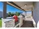 Outdoor kitchen with built-in grill, granite countertops, and tile backsplash at 12657 W Myrtle Ave, Glendale, AZ 85307