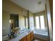 Bathroom with double sinks, soaking tub, and large mirror at 13612 W Cypress St, Goodyear, AZ 85395