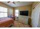 Bedroom featuring a ceiling fan and large TV at 13612 W Cypress St, Goodyear, AZ 85395