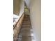 Indoor staircase with wood railing and carpeted steps at 13612 W Cypress St, Goodyear, AZ 85395