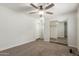 Bedroom with a ceiling fan, carpeted floor, closet with mirrored doors, and white trim at 14846 N 29Th Ave, Phoenix, AZ 85053