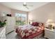 Comfortable bedroom with a window, ceiling fan, and red and white bedding at 14950 W Mountain View Blvd # 3209, Surprise, AZ 85374