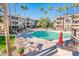 Community pool with lounge chairs, BBQ grills, and palm trees at 14950 W Mountain View Blvd # 3209, Surprise, AZ 85374