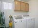 Laundry room with washer, dryer, and overhead cabinets at 16348 W Marconi Ave, Surprise, AZ 85388