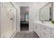 Bathroom with a glass enclosed shower and view of the double vanity with white cabinets and counters at 21754 E Caldwells Ct, Queen Creek, AZ 85142