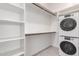 Walk-in closet features built-in shelving, washer and dryer, with tile floor at 21754 E Caldwells Ct, Queen Creek, AZ 85142