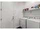 Functional laundry room with side-by-side washer and dryer, white cabinets and shelving for storage at 21754 E Caldwells Ct, Queen Creek, AZ 85142