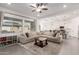 Inviting living room featuring a comfortable sectional sofa, ceiling fan, and an open view into the kitchen at 21754 E Caldwells Ct, Queen Creek, AZ 85142