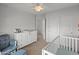 Bright bedroom with a crib, dresser, and comfortable seating at 2403 W Via Dona Rd, Phoenix, AZ 85085
