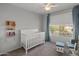 Charming bedroom with a crib and large window at 2403 W Via Dona Rd, Phoenix, AZ 85085