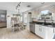 Kitchen with white cabinets, stainless steel appliances, and a dining area with sliding door access to the backyard at 2403 W Via Dona Rd, Phoenix, AZ 85085