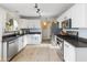 Modern kitchen with white cabinets, stainless steel appliances, and dark countertops at 2403 W Via Dona Rd, Phoenix, AZ 85085