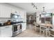 Modern kitchen with white cabinets, stainless steel appliances, and an adjacent dining area at 2403 W Via Dona Rd, Phoenix, AZ 85085