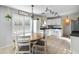 Eat-in kitchen with white cabinets, stainless steel appliances and a round wooden dining table at 2403 W Via Dona Rd, Phoenix, AZ 85085
