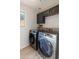 Laundry room with modern washer and dryer, dark cabinets, and wood-look floors at 2403 W Via Dona Rd, Phoenix, AZ 85085