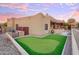 Landscaped backyard featuring a putting green and cornhole game at 317 W Olesen Rd, Phoenix, AZ 85085