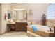 Elegant bathroom with soaking tub, double vanity, and large mirror at 317 W Olesen Rd, Phoenix, AZ 85085