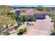 Single-story home with tile roof, desert landscaping, and a paved driveway at 37181 N 103Rd St, Scottsdale, AZ 85262
