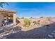 Gravel backyard with desert plants and a grill at 40950 W Bedford Dr, Maricopa, AZ 85138