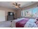 Primary bedroom with large window, dresser, and TV at 40950 W Bedford Dr, Maricopa, AZ 85138
