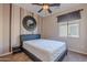 Stylish bedroom with sunburst mirror and ceiling fan at 40950 W Bedford Dr, Maricopa, AZ 85138