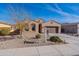Beige house with a two-car garage and drought-tolerant landscaping at 40950 W Bedford Dr, Maricopa, AZ 85138