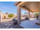 Covered patio with view of the backyard and desert landscaping at 40950 W Bedford Dr, Maricopa, AZ 85138
