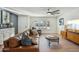 Bright living room featuring hardwood floors, a brown leather couch, and mid-century modern decor at 4942 E Wethersfield Rd, Scottsdale, AZ 85254