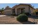 Tan house with a two-car garage and mature shrubbery at 5126 S Sugarberry Ct, Gilbert, AZ 85298