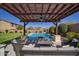 Backyard featuring a covered seating area, a fire pit, a pool with water fountains and plenty of patio space at 5528 E Windstone Trl, Cave Creek, AZ 85331