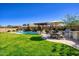 Expansive backyard featuring a pristine pool, barbecue area, lush lawn, and inviting outdoor living spaces at 5528 E Windstone Trl, Cave Creek, AZ 85331