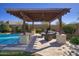 Backyard with a sparkling pool, shaded pergola, and comfortable lounge seating, perfect for relaxing and entertaining at 5528 E Windstone Trl, Cave Creek, AZ 85331