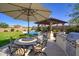 Beautiful backyard with a dining area, built in grill, a lush lawn, and a sparkling pool for outdoor enjoyment at 5528 E Windstone Trl, Cave Creek, AZ 85331