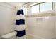White tiled bathroom with a shower/tub combo, white and blue striped shower curtain, and mosaic tile accent at 5528 E Windstone Trl, Cave Creek, AZ 85331