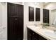 Bathroom featuring dark wood cabinets with double sinks, a large mirror, and a storage cabinet at 5528 E Windstone Trl, Cave Creek, AZ 85331
