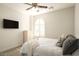 Bright bedroom with a ceiling fan, flat-screen TV, a shuttered window and a dresser for ample storage at 5528 E Windstone Trl, Cave Creek, AZ 85331