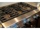 Close-up of a stainless steel cooktop with sturdy grates and precise control knobs at 5528 E Windstone Trl, Cave Creek, AZ 85331