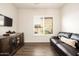 Cozy living room featuring a plush leather sofa, hardwood floors, and stylish furnishings at 5528 E Windstone Trl, Cave Creek, AZ 85331